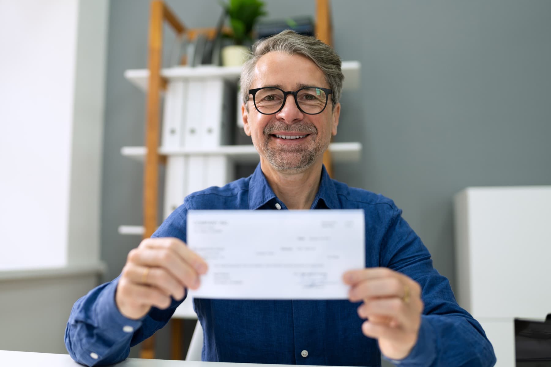 Smiling man holding a check